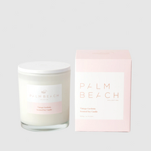 Load image into Gallery viewer, A Palm Beach Collection vintage gardenia scented soy candle in a clear glass jar with a white lid and label, shown next to its light pink packaging box.